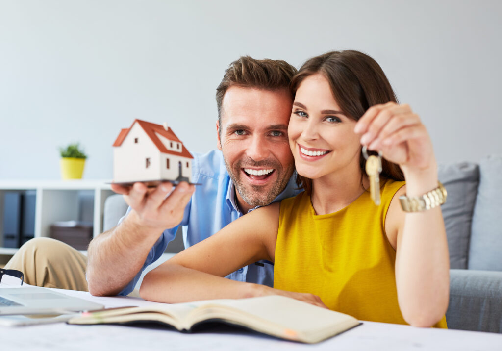 casal sorrindo e satisfeitos com a realização pessoal de ter comprado a casa própria