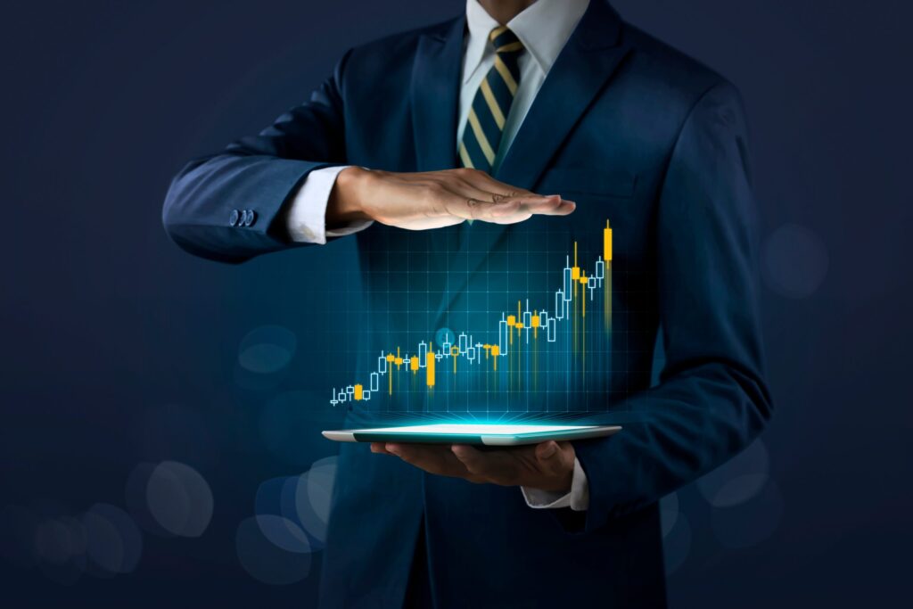 imagem com homem de terno segurrando um tablet e mostrando um grafico de investimentos