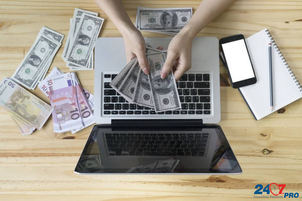 pessoa contanto dinheiro com as mãos apoiada em um notebook