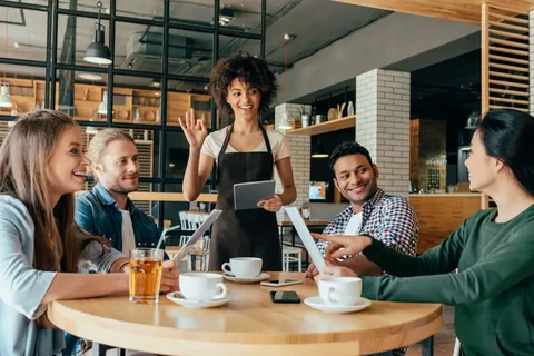 imagem com pessoas em uma mesa fazendo um pedido para uma atendente no restaurante