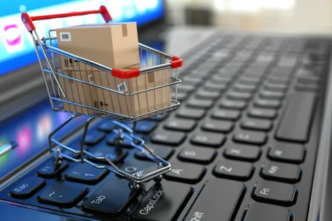 imagem de carrinho de compra em cima de um teclado com caixas de compras para venda de produtos online