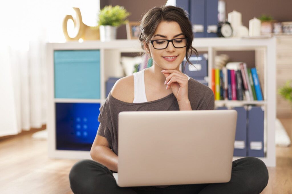 imagem de mulher sentada com um notebook fazendo um curso online investindo em educação