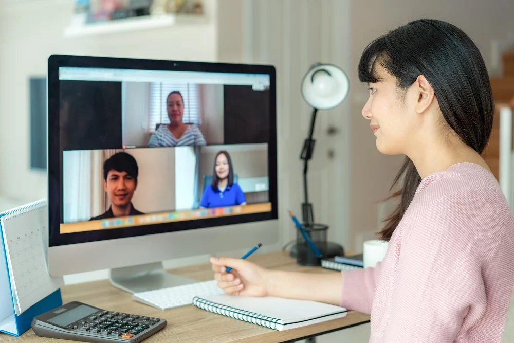 mulher em frente a um computador fazendo reuniao com cliente de assistente virtual